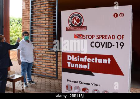 200831 -- KAMPALA, 31 agosto 2020 -- Una guardia di sicurezza controlla la temperatura corporea di un genitore alla scuola Kampala di Kampala, Uganda, 31 agosto 2020. La task force nazionale ugandese incaricata di guidare la lotta contro la pandemia di COVID-19 è quella di rivedere la riapertura delle scuole dopo che sono state chiuse a marzo a seguito dell'epidemia del virus nel paese, ha detto domenica un alto funzionario governativo. UGANDA-KAMPALA-COVID-19-SCHOOL-REOPENING NicholasxKajoba PUBLICATIONxNOTxINxCHN Foto Stock