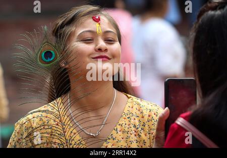 Kathmandu, Bagmati, Nepal. 6 settembre 2023. Una donna sorride mentre posa con le piume di pavone durante la celebrazione del festival Krishna Janmasthami a Kathmandu, Nepal, il 6 settembre 2023. Il festival Krishna Janmasthami viene celebrato ogni anno per celebrare l'anniversario della nascita del Signore indù Krishna. (Immagine di credito: © Sunil Sharma/ZUMA Press Wire) SOLO USO EDITORIALE! Non per USO commerciale! Foto Stock