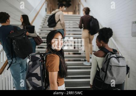 Ritratto di una studentessa felice con amici multirazziali all'università Foto Stock