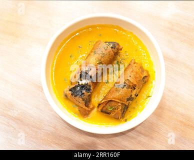 Involtini di salsiccia alla Morcilla con salsa d'arancia su un tavolo di legno. Foto Stock