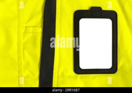 Modello bianco bianco di carta d'identità su un abbigliamento da lavoro ad alta visibilità Foto Stock