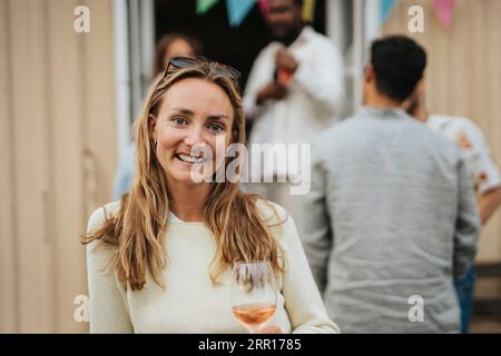 Ritratto di una giovane donna sorridente con i capelli lunghi durante la cena alla caffetteria Foto Stock