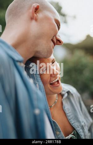 Giovane donna che rideva con un amico maschio durante la cena al bar Foto Stock