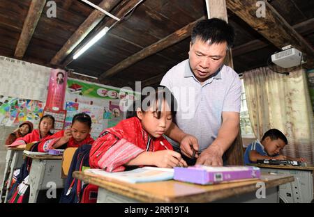 200910 -- NANNING, 10 settembre 2020 -- insegnante Yu Qigui tutors Students at Wengjiang Primary School in Jiangliu Village, Longji Township of South China S Guangxi Zhuang Autonomous Region, 7 luglio 2020. Migliaia di insegnanti si attengono ai loro posti nelle regioni montagnose del Guangxi, uno dei principali campi di battaglia per la riduzione della povertà nel paese. CINA-GUANGXI-REGIONI MONTUOSE-INSEGNANTI CN LUXBOAN PUBLICATIONXNOTXINXCHN Foto Stock