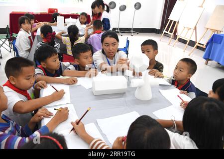 200910 -- NANNING, 10 settembre 2020 -- l'insegnante Na Xian, 22 anni, insegna in una lezione di disegno in una scuola elementare nel villaggio di Houlong, Sicheng Township della regione autonoma del Guangxi Zhuang della Cina meridionale, 8 settembre 2020. Migliaia di insegnanti si attengono ai loro posti nelle regioni montagnose del Guangxi, uno dei principali campi di battaglia per la riduzione della povertà nel paese. CINA-GUANGXI-REGIONI MONTUOSE-INSEGNANTI CN ZHOUXHUA PUBLICATIONXNOTXINXCHN Foto Stock