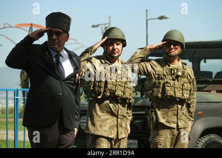 Smirne, Turchia - 30 agosto 2023: In Piazza della Repubblica durante le celebrazioni del giorno della Vittoria, un orgoglioso veterano di guerra turco, affiancato da due soldati, si trova in piedi Foto Stock