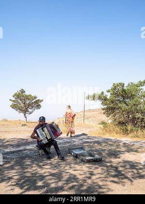 Voghaberd, Armenia - 25 agosto 2023: Musicista fisarmonicista vicino alla piattaforma di osservazione dell'Arco di Charents, nel villaggio di Voghaberd, Kotayk Foto Stock