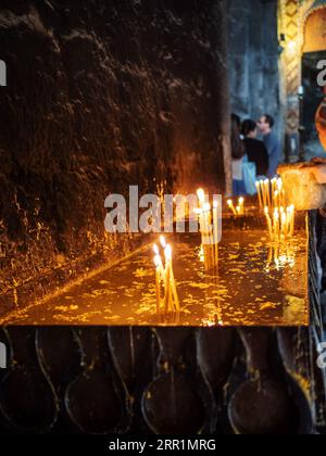 Sevan, Armenia - 25 agosto 2023: Le candele in memoria bruciano nella chiesa di Surp Arakelots nel monastero di Sevanavank. Il monastero di Sevan fu fondato nel 874 Foto Stock