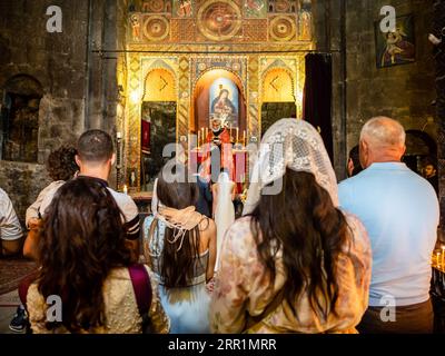 Sevan, Armenia - 25 agosto 2023: Cerimonia nuziale nella chiesa Surp Arakelots del monastero di Sevanavank. Il monastero di Sevan fu fondato nel 874 Foto Stock