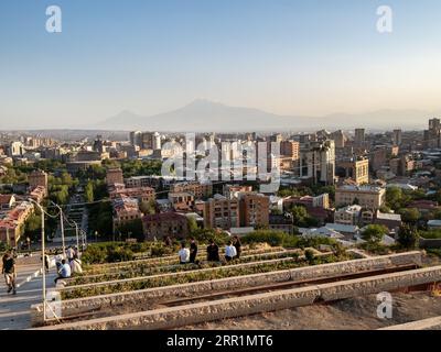 Erevan, Armenia - 23 agosto 2023: Vista sopra le aiuole sulle scale delle Cascate nella città di Erevan e la montagna all'orizzonte al tramonto estivo Foto Stock