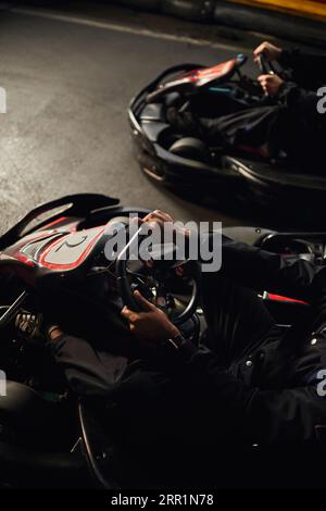 vista dall'alto di due diversi piloti di go-kart che guidano su un circuito al coperto, gare di velocità e sport motoristici Foto Stock