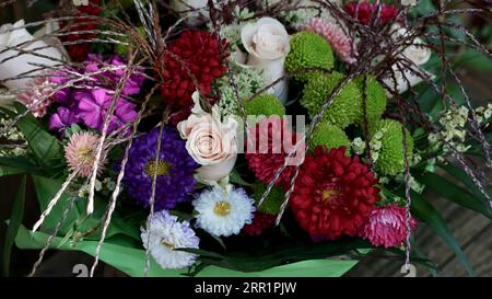 Bouquet di fiori in un involucro verde. Foto Stock