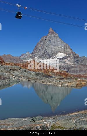 ZERMATT, SVIZZERA, 13 luglio 2022: Funivia sopra un mMineral Landscape ai piedi della vetta del Cervino, con rifacimento in un piccolo lago d'acqua Foto Stock