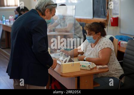 200927 -- BUCAREST, 27 settembre 2020 -- Un uomo che indossa una maschera facciale mostra la sua carta d'identità prima di votare durante le elezioni locali a Bucarest, in Romania, il 27 settembre 2020. Foto di /Xinhua ROMANIA-BUCAREST-COVID-19-ELEZIONI GabrielxPetrescu PUBLICATIONxNOTxINxCHN Foto Stock