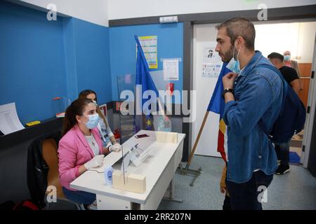 200927 -- BUCAREST, 27 settembre 2020 -- Un uomo rimuove la maschera facciale per verificare la sua identità prima di votare durante le elezioni locali a Bucarest, in Romania, il 27 settembre 2020. Foto di /Xinhua ROMANIA-BUCAREST-COVID-19-ELEZIONI GabrielxPetrescu PUBLICATIONxNOTxINxCHN Foto Stock