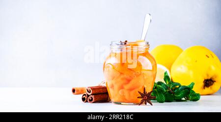 Marmellata di quince autunnale o confiture in vaso di vetro con cannella e anice su sfondo grigio Foto Stock
