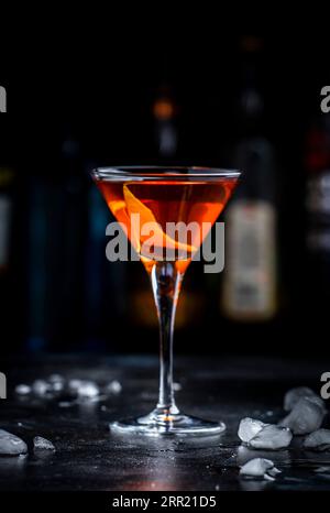 Bobby Burns forte cocktail drink con whisky scotch, vermouth e liquore in un bicchiere di martini, sfondo scuro da bar Foto Stock