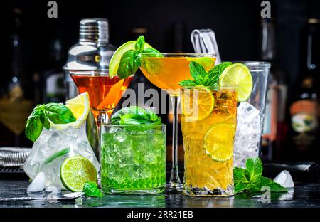 Cocktail alcolici con gin, whisky, vermouth e liquori, sfondo nero bar, atmosfera notturna Foto Stock