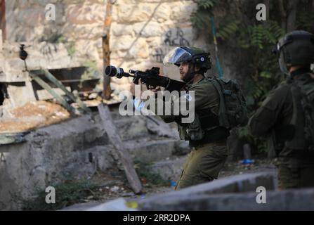 201009 -- HEBRON, 9 ottobre 2020 -- un soldato israeliano punta la sua arma contro i manifestanti palestinesi durante gli scontri a seguito di una protesta contro l'espansione degli insediamenti ebraici nella città di Hebron in Cisgiordania, il 9 ottobre 2020. Foto di /Xinhua MIDEAST-HEBRON-CLASHES MamounxWazwaz PUBLICATIONxNOTxINxCHN Foto Stock