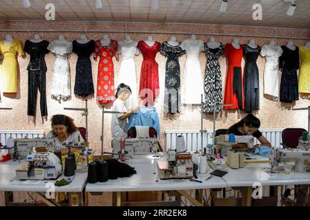 201010 -- URUMQI, 10 ottobre 2020 -- i lavoratori fanno vestiti in una cooperativa di cucito di abbigliamento presso il villaggio di Daxi nella contea di Yuli, nella regione autonoma di Xinjiang Uygur della Cina nord-occidentale, 4 settembre 2020. Grazie agli sforzi faticosi di tutte le parti, sono stati compiuti grandi progressi nello Xinjiang. Dal 2014 al 2019, è stato sostenuto un solido slancio economico con un tasso medio annuo di crescita del PIL del 7,2%. Il tenore di vita della popolazione locale è notevolmente migliorato con una crescita media annua del 9,1% del reddito disponibile abitativo pro capite, e più di 2,92 milioni dei 3,09 milioni di re Foto Stock