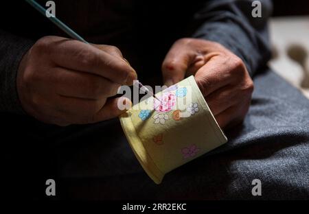 201010 -- SRINAGAR, 10 ottobre 2020 -- Un artigiano di cartapesta lavora su un prodotto nel suo laboratorio nella città di Srinagar, la capitale estiva del Kashmir controllato dagli indiani, 10 ottobre 2020. KASHMIR-SRINAGAR-ARTIGIANATO JavedxDar PUBLICATIONxNOTxINxCHN Foto Stock