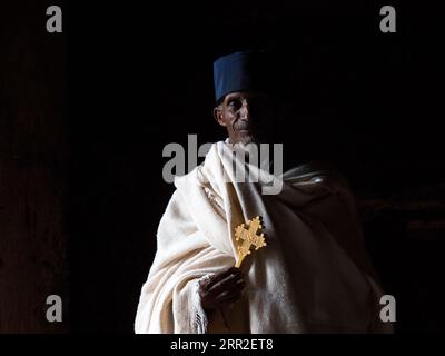 Sacerdote con croce in luce buia, Gondar, regione di Amhara, Etiopia Foto Stock