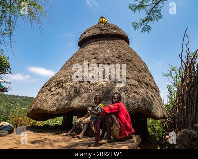 Abitanti di fronte alla capanna nel villaggio, tribù Konso, Etiopia Foto Stock