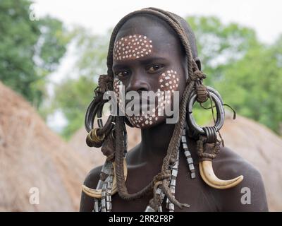 Ragazza della tribù dei Mursi con copricapo e face painting, ritratto, Etiopia Foto Stock