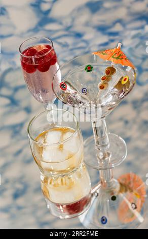 Bevande alcoliche su superficie riflettente su sfondo modellato Foto Stock