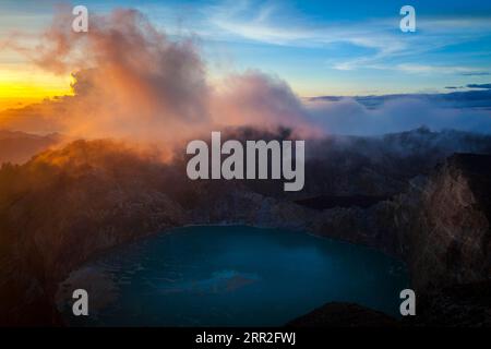 Alba al vulcano Kelimutu, nebbia sul cratere con il lago cratere, Parco Nazionale Kelimutu, Flores, Nusa Tenggara Timur, Indonesia Foto Stock