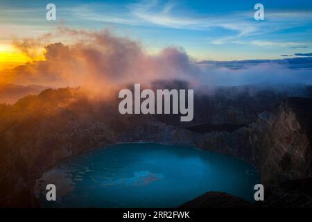 Alba al vulcano Kelimutu, nebbia sul cratere con il lago cratere, Parco Nazionale Kelimutu, Flores, Nusa Tenggara Timur, Indonesia Foto Stock