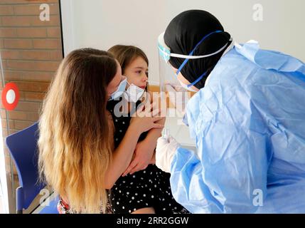 201012 -- PETAH TIKVA, 12 ottobre 2020 -- Un operatore sanitario preleva un campione di tampone da un bambino per il test rapido del coronavirus Sofia al centro di servizi sanitari Clalit nella città centrale israeliana di Petah Tikva, l'11 ottobre 2020. Foto di /Xinhua ISRAEL-PETAH TIKVA-FAST COVID-19 TEST GilxCohenxMagen PUBLICATIONxNOTxINxCHN Foto Stock