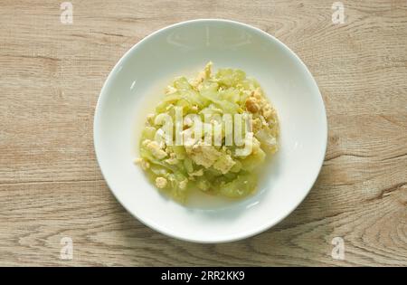 mescolare la fetta di melone amaro fritta con l'uovo in salsa sul piatto Foto Stock