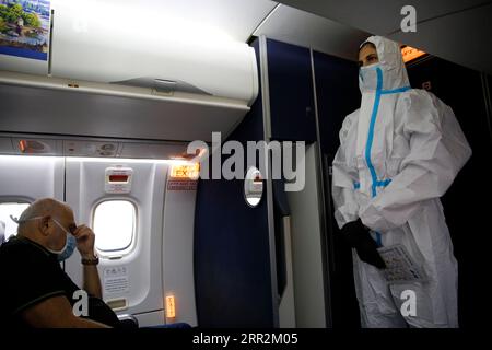 201014 -- TEL AVIV, 14 ottobre 2020 -- Una hostess con Israir Airlines che indossa un equipaggiamento protettivo lavora mentre l'aereo si prepara a decollare dall'aeroporto internazionale Ben Gurion vicino a Tel Aviv alla città turistica israeliana di Eilat, nel Mar Rosso meridionale, in mezzo alla pandemia di COVID-19, il 14 ottobre 2020. Foto di /Xinhua ISRAEL-TEL AVIV-COVID-19-FLIGHT GilxCohenxMagen PUBLICATIONxNOTxINxCHN Foto Stock