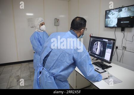 201017 -- BAGHDAD, 17 ottobre 2020 -- il Dr. Mohammed Abdul-Hussein R e il tecnico TC Hanan Jamal esaminano le immagini polmonari al centro al-Shifaa a Baghdad, Iraq, 12 ottobre 2020. In un ospedale specializzato per la COVID-19 nella capitale irachena di Baghdad, una TAC donata dalla Cina, apparecchiature radiologiche mobili e altre forniture mediche stanno salvando vite nella battaglia in prima linea contro la pandemia di COVID-19. Già 400 pazienti hanno beneficiato dell'importante donazione medica. PER ANDARE CON Spotlight: La TAC donata dalla Cina, la radiografia mobile salva vite nell'ospedale specializzato per COVID-19 in Iraq Iraq-BAGHDAD-HOSPITAL-CHINA-DO Foto Stock