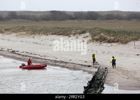 Arrivo del guardiano degli uccelli sull'isola di Minsener Oog, sbarco con un gommone sulla spiaggia, nel Parco Nazionale del Mare di Wadden della bassa Sassonia Foto Stock