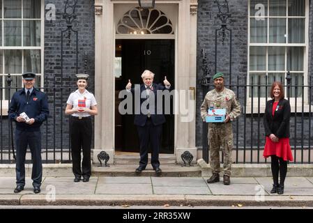 201024 -- LONDRA, 24 ottobre 2020 -- il primo ministro britannico Boris Johnson C posa per le foto con raccolte fondi per l'appello della Royal British Legion S Poppy e il personale di servizio fuori Downing Street, a Londra, in Gran Bretagna, il 23 ottobre 2020. Foto di /Xinhua BRITAIN-LONDON-PM-POPPY APPEAL RayxTang PUBLICATIONxNOTxINxCHN Foto Stock