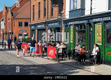 Persone sedute all'esterno dell'Humber Dock Bar & Grill, in Humber Dock Street, Hull, Humberside, East Yorkshire, Inghilterra, Regno Unito Foto Stock