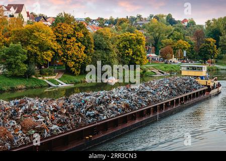 Industria dei trasporti. La chiatta della nave trasporta i rottami metallici e la sabbia con la ghiaia. Chiatta caricata con metallo di scarto è sulla strada. Rottami di metallo Foto Stock