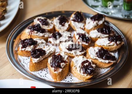 Tosta con crema di tonno spalmata e cipolle caramellate su un piatto. Foto Stock