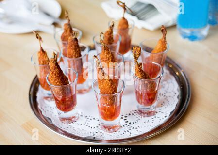 Gamberi fritti in un bicchierino con salsa dolce al peperoncino su un vassoio Foto Stock