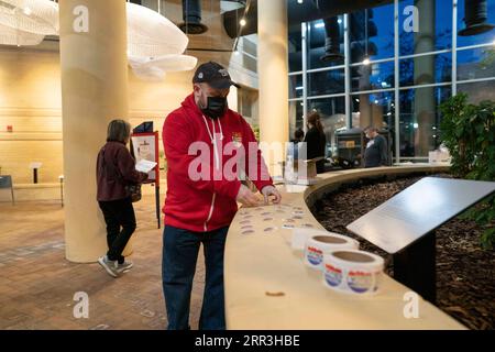 201103 -- WASHINGTON, 3 novembre 2020 -- Un elettore prende un adesivo dopo aver lanciato il suo voto in un collegio elettorale ad Arlington, Virginia, Stati Uniti, 3 novembre 2020. Gli elettori delle principali città lungo la costa orientale degli Stati Uniti hanno iniziato a votare martedì presto, mentre i sondaggi continuano ad aprirsi in tutto il paese per decidere la presidenza. ELEZIONI PRESIDENZIALI statunitensi LiuxJie PUBLICATIONxNOTxINxCHN Foto Stock