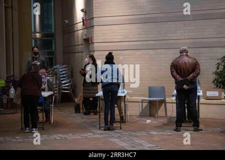 201103 -- WASHINGTON, 3 novembre 2020 -- gli elettori fanno il check-in in una sede elettorale ad Arlington, Virginia, Stati Uniti, 3 novembre 2020. Gli elettori delle principali città lungo la costa orientale degli Stati Uniti hanno iniziato a votare martedì presto, mentre i sondaggi continuano ad aprirsi in tutto il paese per decidere la presidenza. ELEZIONI PRESIDENZIALI statunitensi LiuxJie PUBLICATIONxNOTxINxCHN Foto Stock