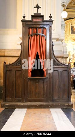 Saragossa, Spagna - 14 agosto 2023: Vecchio confessionale in legno con cortina rossa nella Cattedrale-Basilica di nostra Signora del pilastro Foto Stock