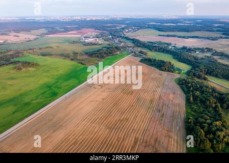la vista panoramica aerea sullo splendido campo autunnale con colture mietute è una pianta per l'industria verde Foto Stock