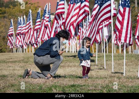 201113 -- PECHINO, 13 novembre 2020 -- Un padre cerca di fare una foto per sua figlia a Plano, Texas, negli Stati Uniti, l'11 novembre 2020. A Plano sono state allestite mille bandiere degli Stati Uniti per onorare i veterani durante il Veterans Day. Foto di /Xinhua XINHUA FOTO DEL GIORNO DanxTian PUBLICATIONxNOTxINxCHN Foto Stock