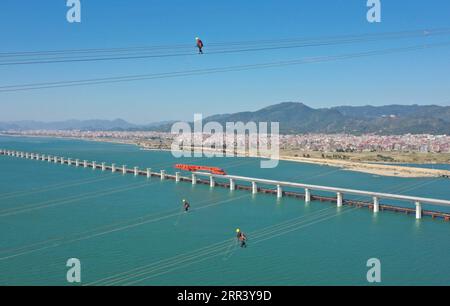 201114 -- PECHINO, 14 novembre 2020 -- foto aerea scattata il 13 novembre 2020 mostra i tecnici che mantengono linee elettriche ad alta tensione sopra le acque nella Baia di Meizhou, nella provincia del Fujian della Cina sud-orientale. XINHUA FOTO DEL GIORNO LinxShanchuan PUBLICATIONxNOTxINxCHN Foto Stock