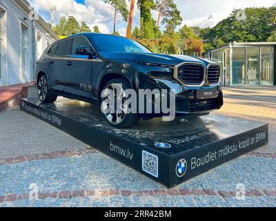 Jurmala, Lettonia - 2 settembre 2023: La nuova BMW XM è esposta sulla strada vicino alla sala concerti Dzintari. Iscrizione sul piedistallo in lettone Foto Stock