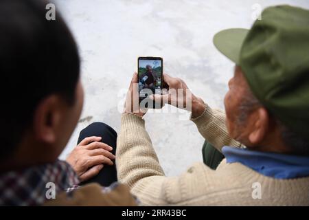 201119 -- XIANGXI, 19 novembre 2020 -- Peng Guofei L mostra i suoi brevi video al villager Peng Hongyun al villaggio Yangmu di Furong Township a Xiangxi Tujia e Miao Autonomous Prefecture, Central China S Hunan Province, 15 novembre 2020. Peng Guofei, 75 anni, è noto online come nonno Fei. È nato e cresciuto nel remoto villaggio di Yangmu situato nelle profondità delle montagne di Wuling. Con l'aiuto di funzionari locali per la lotta alla povertà, gli abitanti del villaggio hanno accesso a Internet negli ultimi anni, poiché l'intero villaggio abbraccia la copertura completa del segnale 4G. All'inizio del 2020, Peng ha seguito corsi Internet nel villaggio per Foto Stock