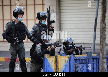 201120 -- HEBRON, 20 novembre 2020 -- i membri della polizia di frontiera israeliana puntano le loro armi contro i manifestanti palestinesi durante gli scontri, a seguito di una protesta contro l'espansione degli insediamenti ebraici, nella città di Hebron, in Cisgiordania, il 20 novembre 2020. Foto di /Xinhua MIDEAST-HEBRON-CLASHES MamounxWazwaz PUBLICATIONxNOTxINxCHN Foto Stock